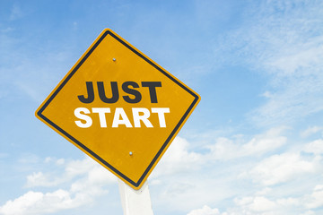 Yellow road sign with text on blue sky.