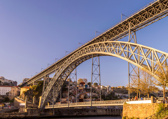 Closeup of the bridge D. Luis I hit by a golden sunlight against clear blue sky