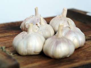 a bunch of garlic on a wooden board close up shot