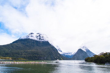 A stunning scene of nature with snow mountain and waterfalls at Milford Sound, New Zealand.