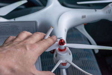 A man reads the instructions to the quadcopter and holding a cigarette
