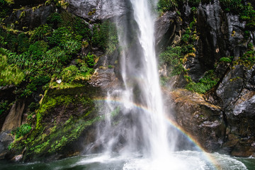 Fototapeta na wymiar A stunning scene under waterfalls while cruising at Milford Sound, New Zealand.