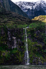 A stunning scene of nature with snow mountain and waterfalls at Milford Sound, New Zealand.