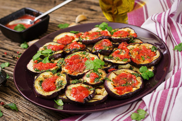 Eggplant grilled with tomato sauce, garlic, cilantro and mint. Vegan food. Grilled aubergine.