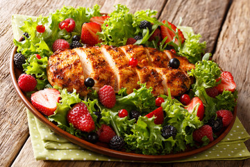 grilled chicken served with summer berries and lettuce close-up on the table. horizontal