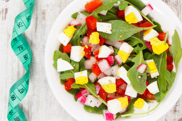 Centimeter and fresh salad in glass bowl, healthy nutrition, dieting and slimming concept