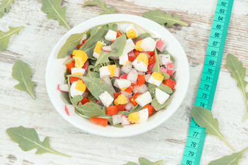 Centimeter and fresh salad in glass bowl, healthy nutrition, dieting and slimming concept