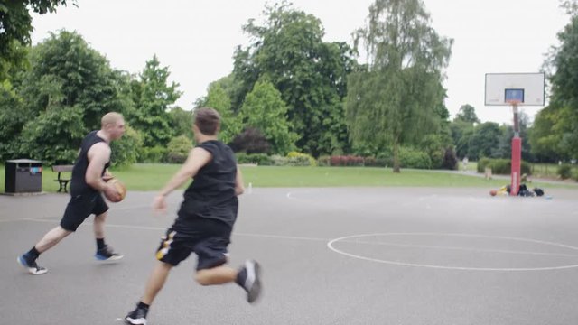 Steadicam shot of 3 basketball players in a 3 man weave, in slow motion 