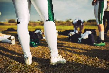 Closeup of football players on a field with their equipment