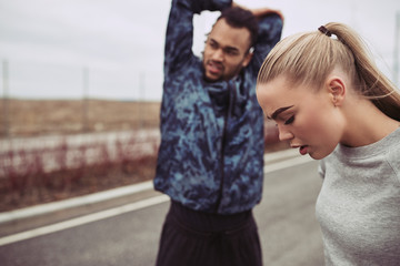 Young couple doing stretches before a jog together