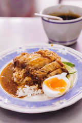 Crispy pork belly with rice pouring with gravy served with half of boiled egg.