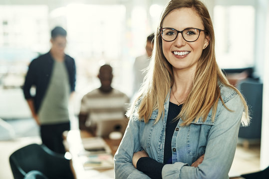 Confident young businesswoman smiling while standing in an office
