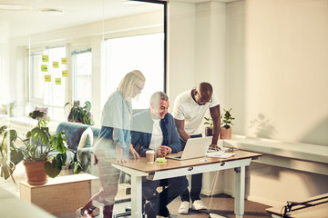 Smiling group of diverse businesspeople working together on a la
