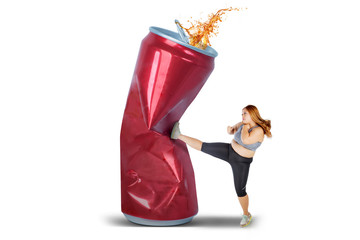 Beautiful woman kicking a can of soft drink