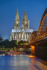 The famous Cologne Cathedral and the Hohenzollern railway bridge at dusk