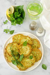 Pancakes from zucchini, served with sour cream or yogurt and various herbs. Useful vegetarian food.