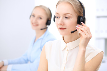 Bright  call center office. Two blonde women in a headset