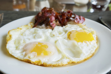 Fried egg and bacon slices on the plate