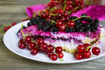 pie with a wig and currant on a plate on an old wooden background