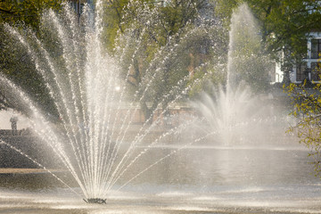 Spray from the fountain in the city as a background