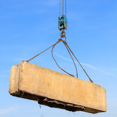 The crane loads old concrete blocks at the construction site