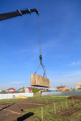 The crane loads old concrete blocks at the construction site