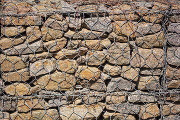 Stone wall in a metal grid as a background