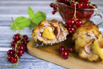 meat rolls stuffed with ham and cheese on an old wooden background