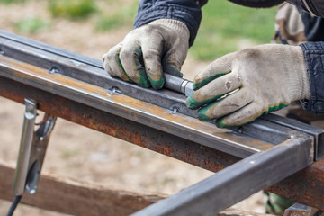 A man makes metal doors in a factory