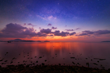 Fototapeta na wymiar Long exposure image of dramatic sunset or sunrise,sky clouds over tropical sea and milky way galaxy.