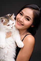 Young beautiful Asian woman holding Persian cat