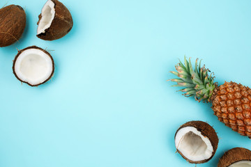 Coconuts and pineapple on blue background with copyspace