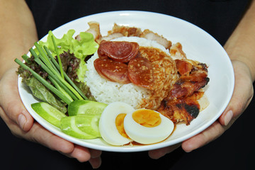 Jasmine rice with meat and boiled egg topped red sweet sauce .