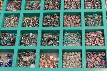 Unique pieces for bracelets, sorted in boxes for sale. View from above.