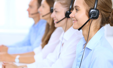 Call center operator in headset while consulting client. Telemarketing or phone sales