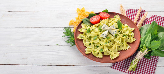 Pasta with spinach, and blue cheese. On a wooden background. Top view. Copy space.