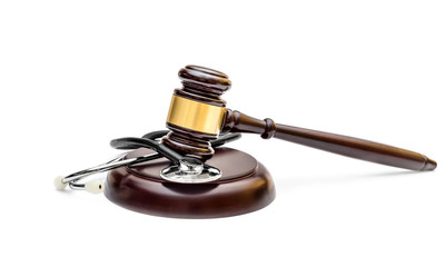 Gavel with stethoscope on stand. Isolated on white. Medical law concept.