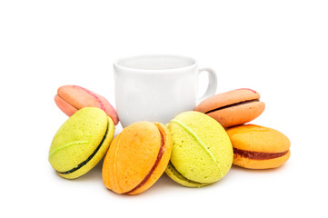 Cup of coffee with colorful macaroons on white background.
