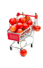 Shopping cart with cherries on white.