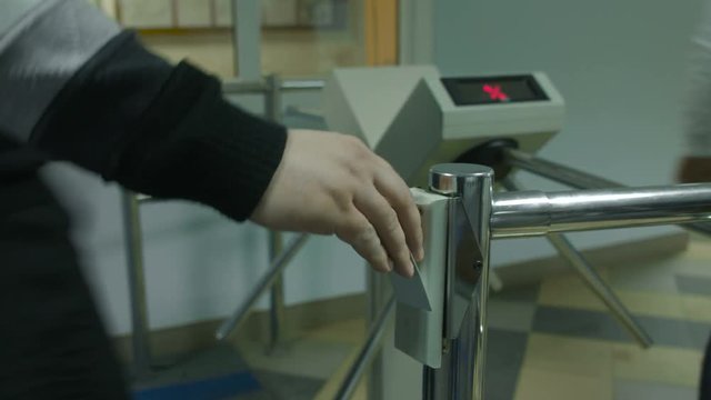 Men pass the electronic turnstile with plastic card at the office