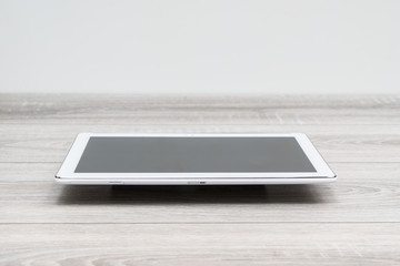 A view of a tablet on the wooden table