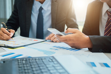 Business people partner negotiating a contract, they are pointing on a document and discussing together,Two businessmen are negotiating in office.