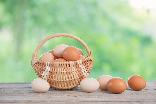 raw eggs in basket on wooden table outdoor