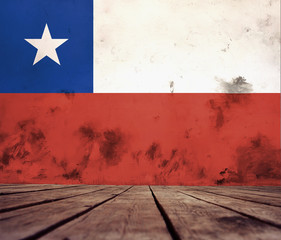 The floor of planks and plastered wall with a painted flag of Chile.