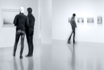 people in the art gallery center in monochrome blue tonality