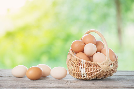 raw eggs in basket on wooden table outdoor