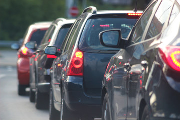 cars stopping in front of a red traffic light