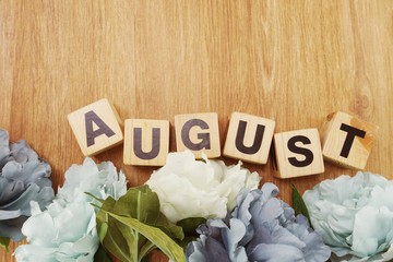august alphabet letter wooden cube with space copy on wooden background and flower decoration - obrazy, fototapety, plakaty