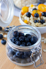 fresh blueberries in a clear glass jar, Breakfast ingredients blueberries and oatmeal. healthy Breakfast concept, selective focus