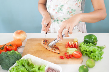Woman cutting grilled chicken for salad, Healthy living and food concept